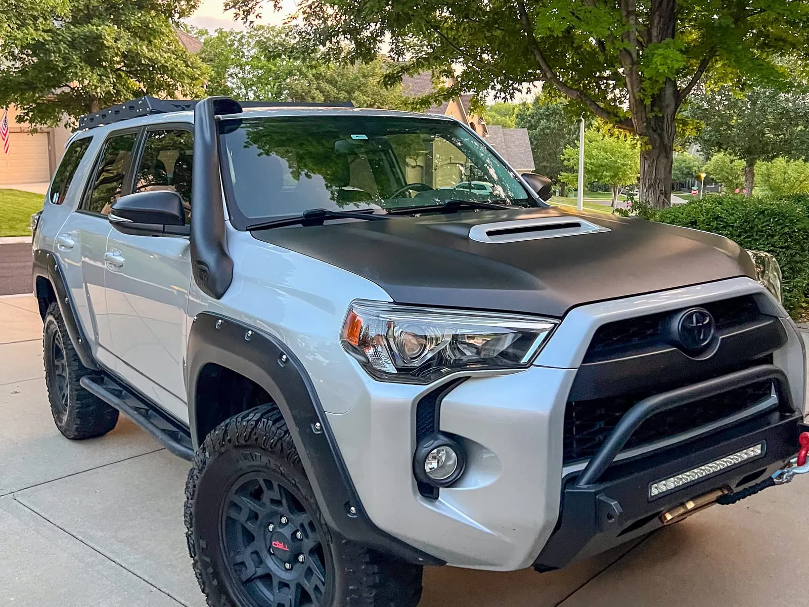 Silver Toyota 4Runner TRD on a driveway, black wheels and off-road tires cleaned