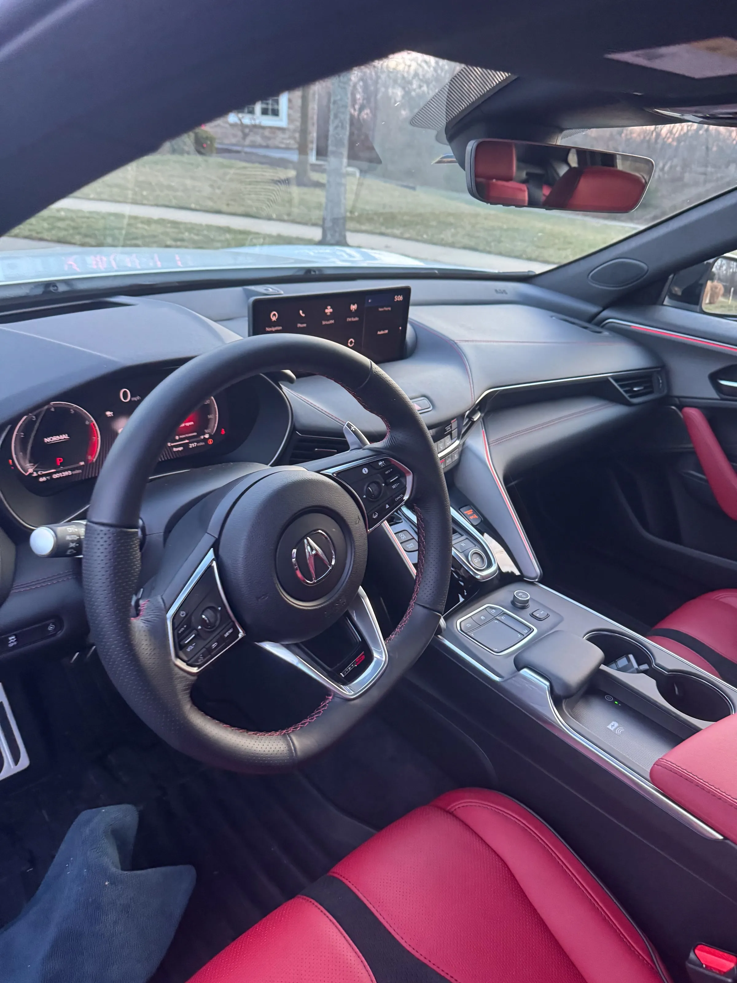 Driver side of an Acura TLX Type S with red leather seats, cleaned dash, screen and steering wheel