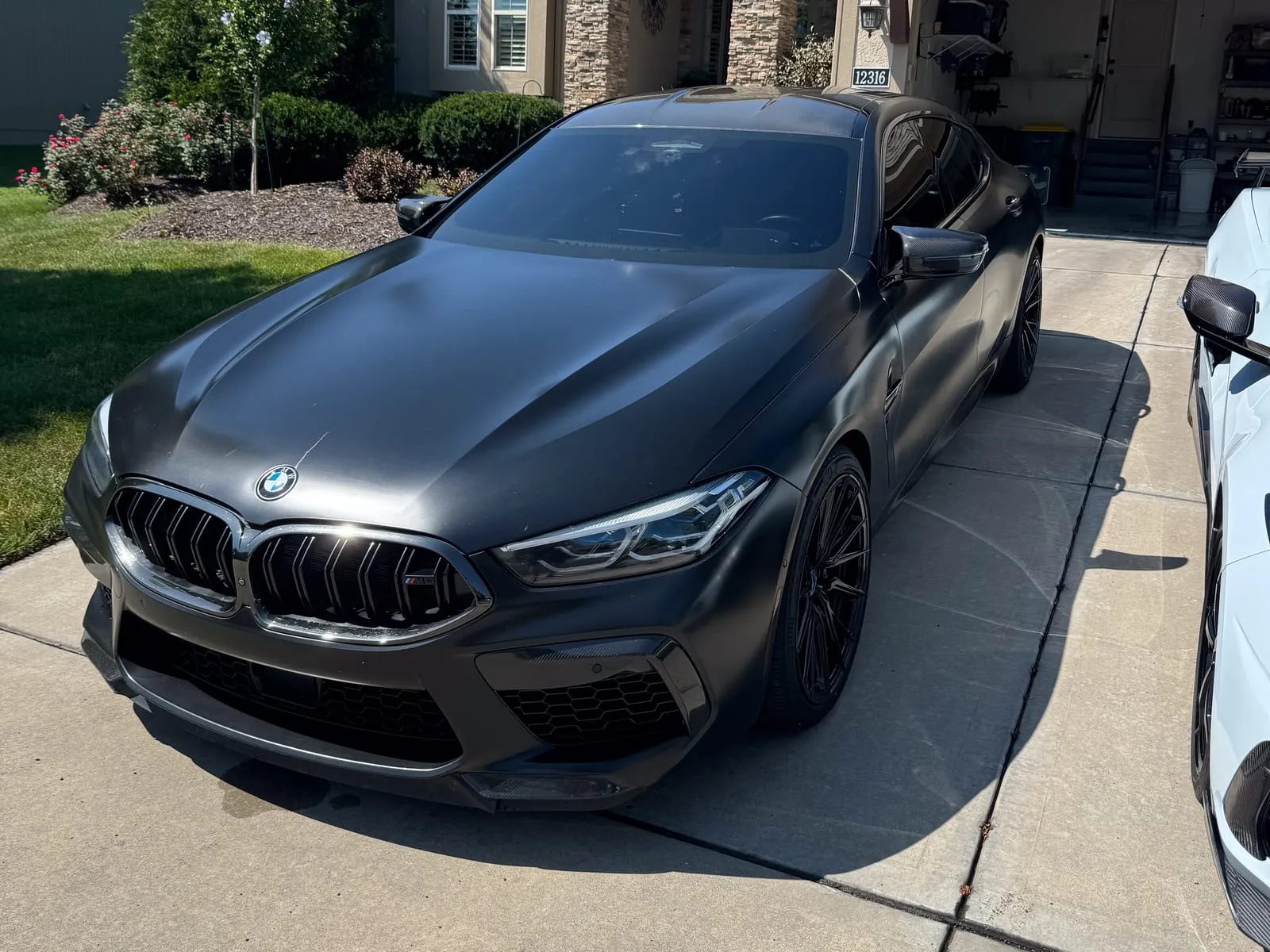 Black BMW M5 photographed head-on in a driveway, kidney grille and headlights cleaned
