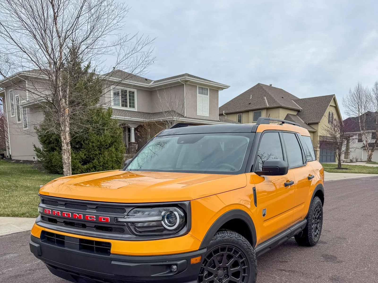 Orange Ford Bronco Sport parked on a driveway, roof rails and wheels cleaned