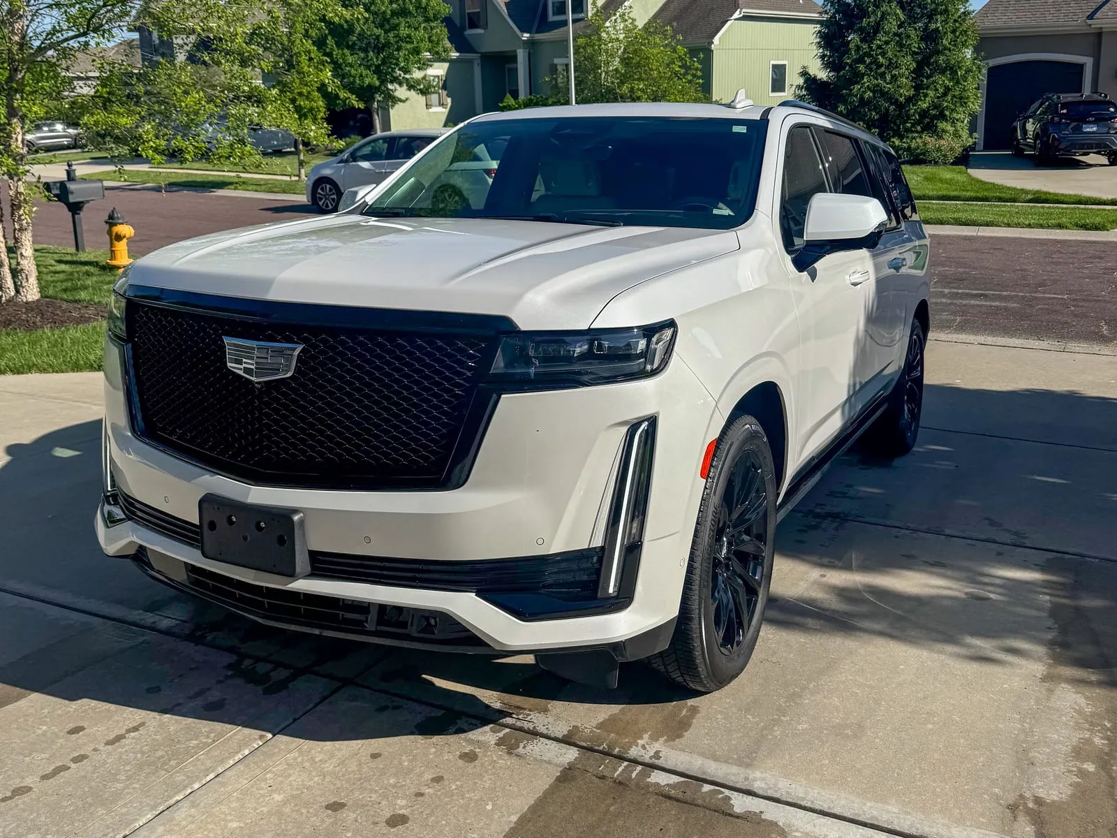 White Cadillac Escalade photographed head-on, vertical light bars and grille cleaned