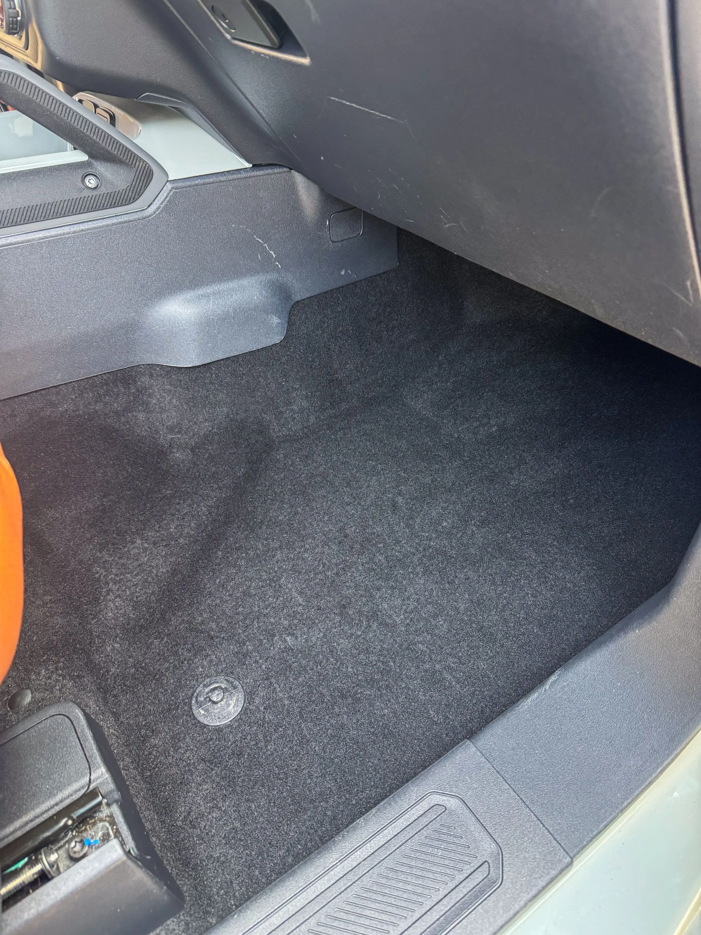Driver footwell of a Ford Bronco with the floor mat removed and the carpet underneath cleaned