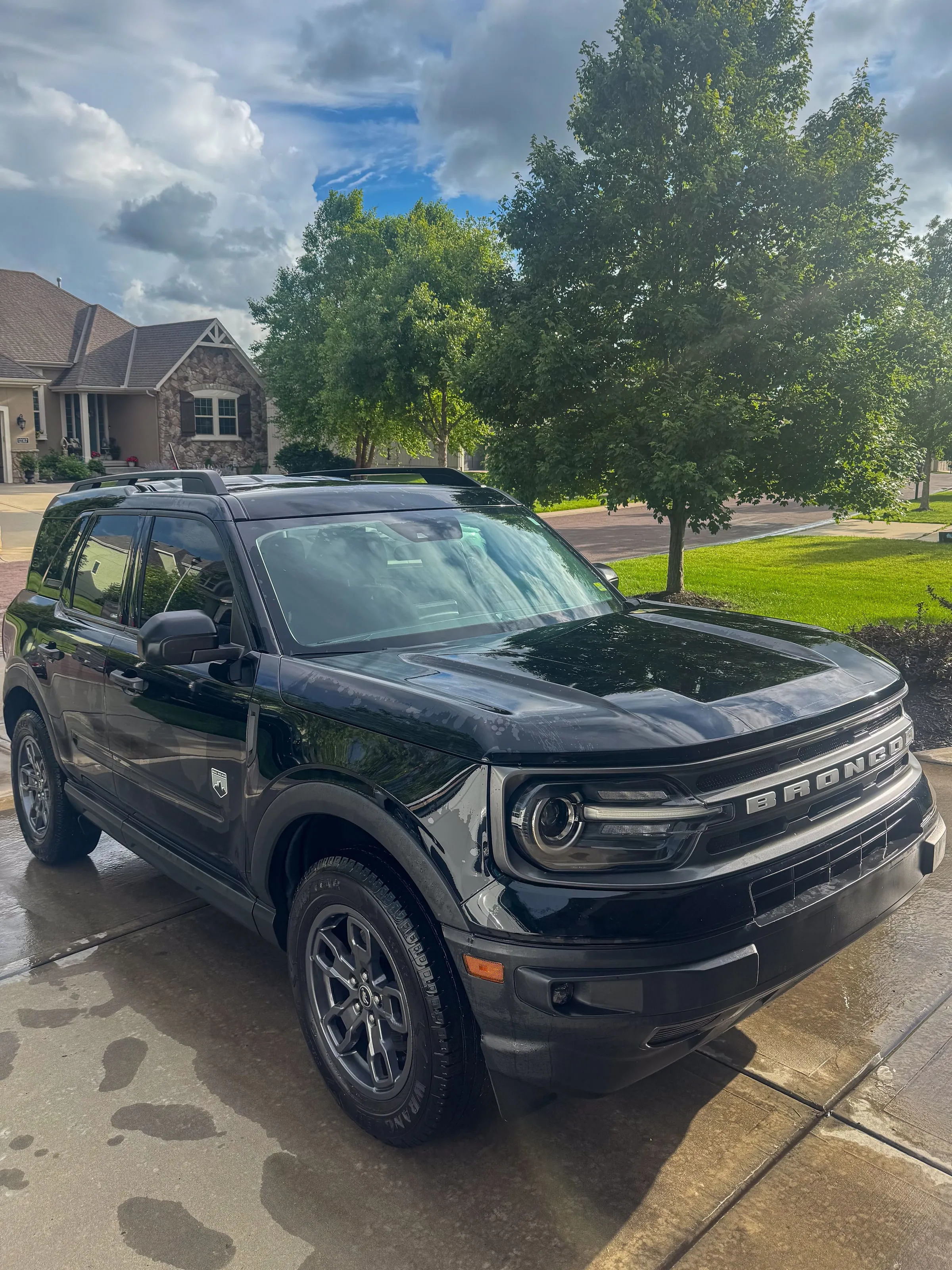 Black Ford Bronco Sport on a wet driveway after washing, wheels and trim cleaned