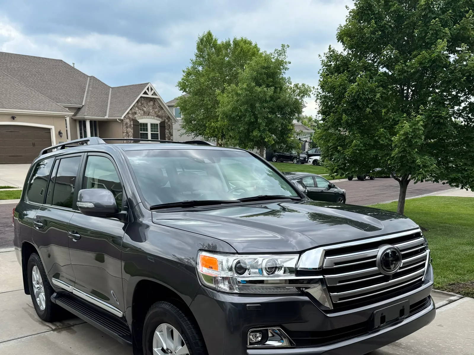 Black Toyota Land Cruiser head-on in a driveway, chrome grille and bumper cleaned