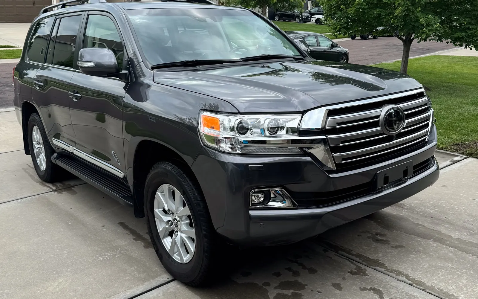 A dark grey Toyota Land Cruiser, clean and glossy in a driveway