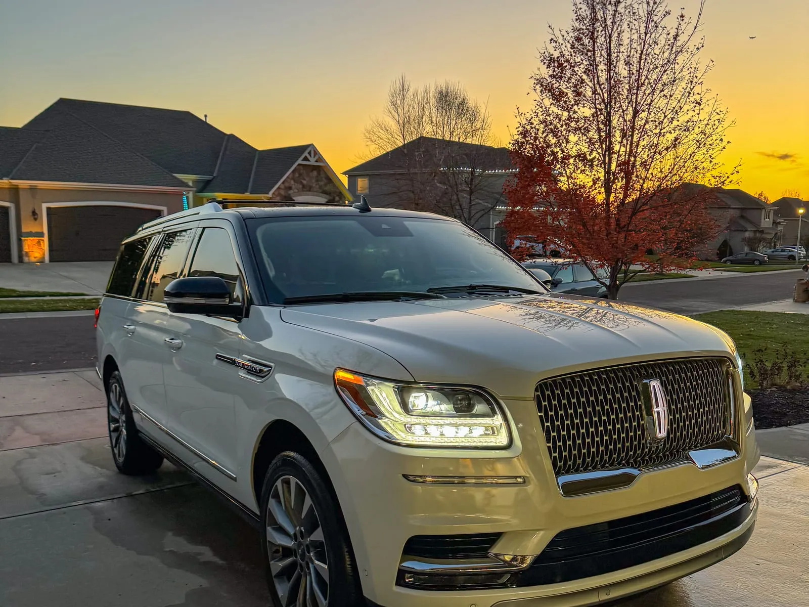 Lincoln Navigator on a driveway at sunset, chrome grille catching the low orange light
