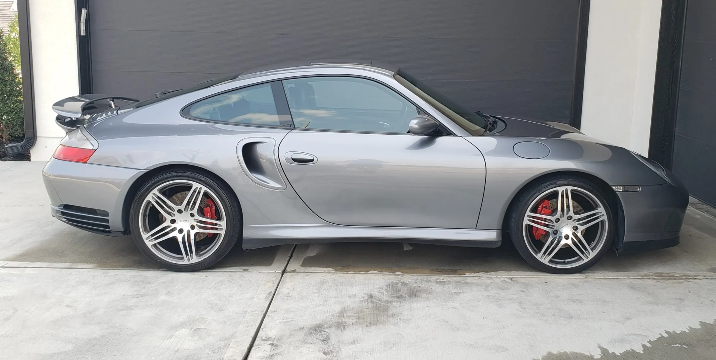 Silver Porsche 911 Turbo photographed side-on in front of a garage, wheels and paint cleaned