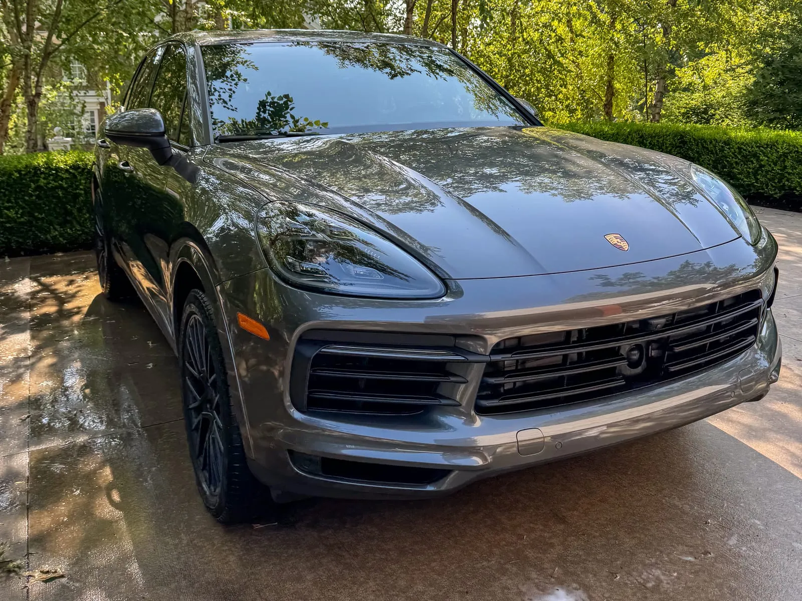 Grey Porsche Cayenne on a driveway after washing, wheels cleaned and paint holding a reflection