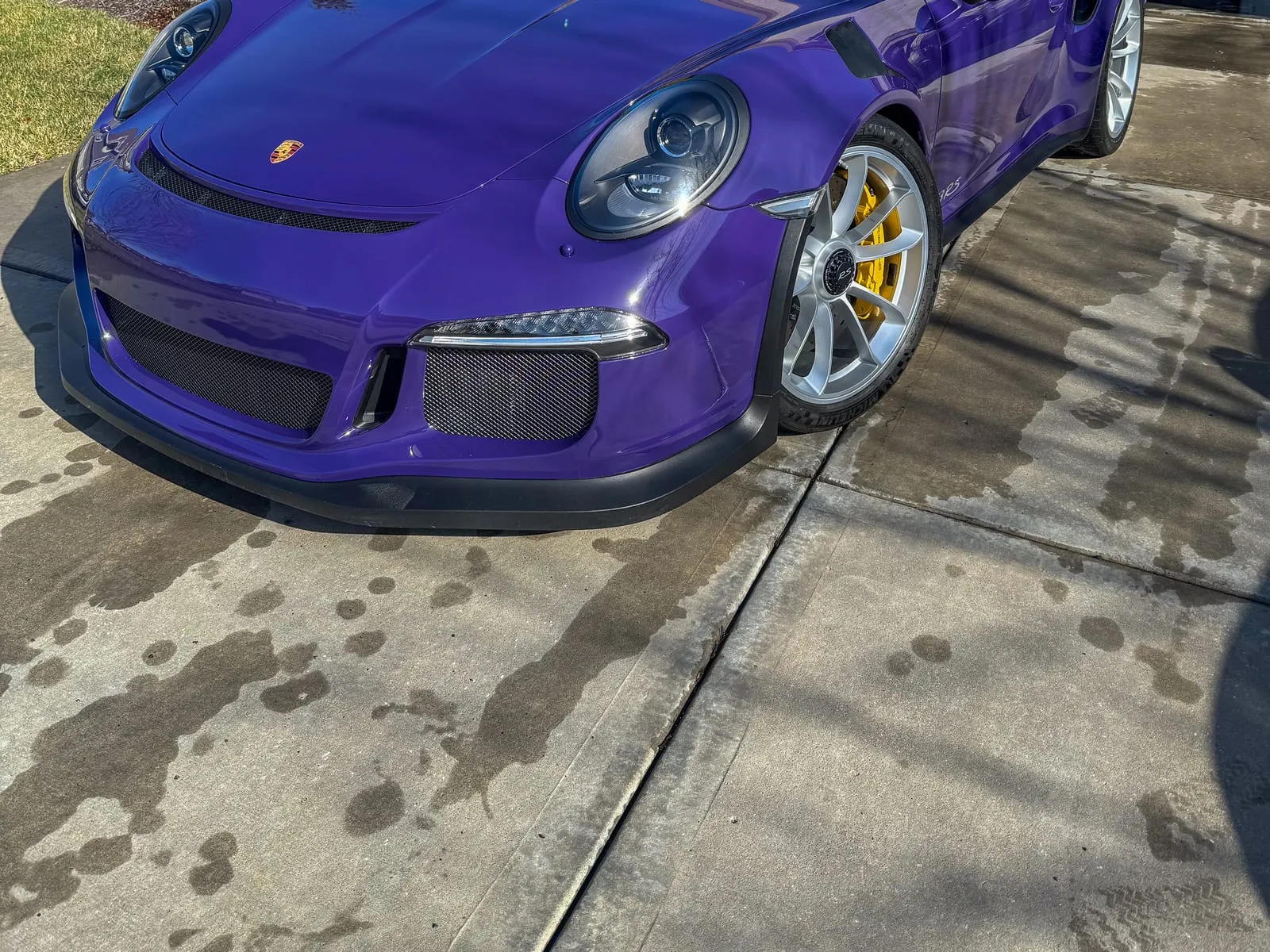 Purple Porsche 911 GT3 RS parked on a driveway, front splitter and yellow calipers clean