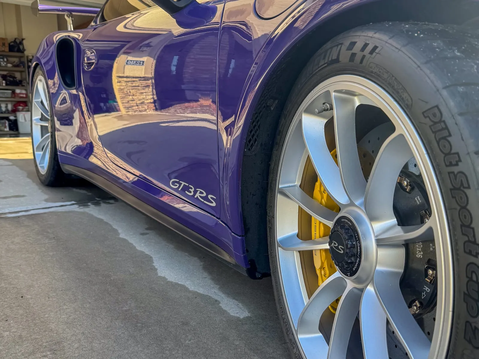 Close view of a purple Porsche 911 GT3 RS rear arch and center-lock wheel with a yellow caliper