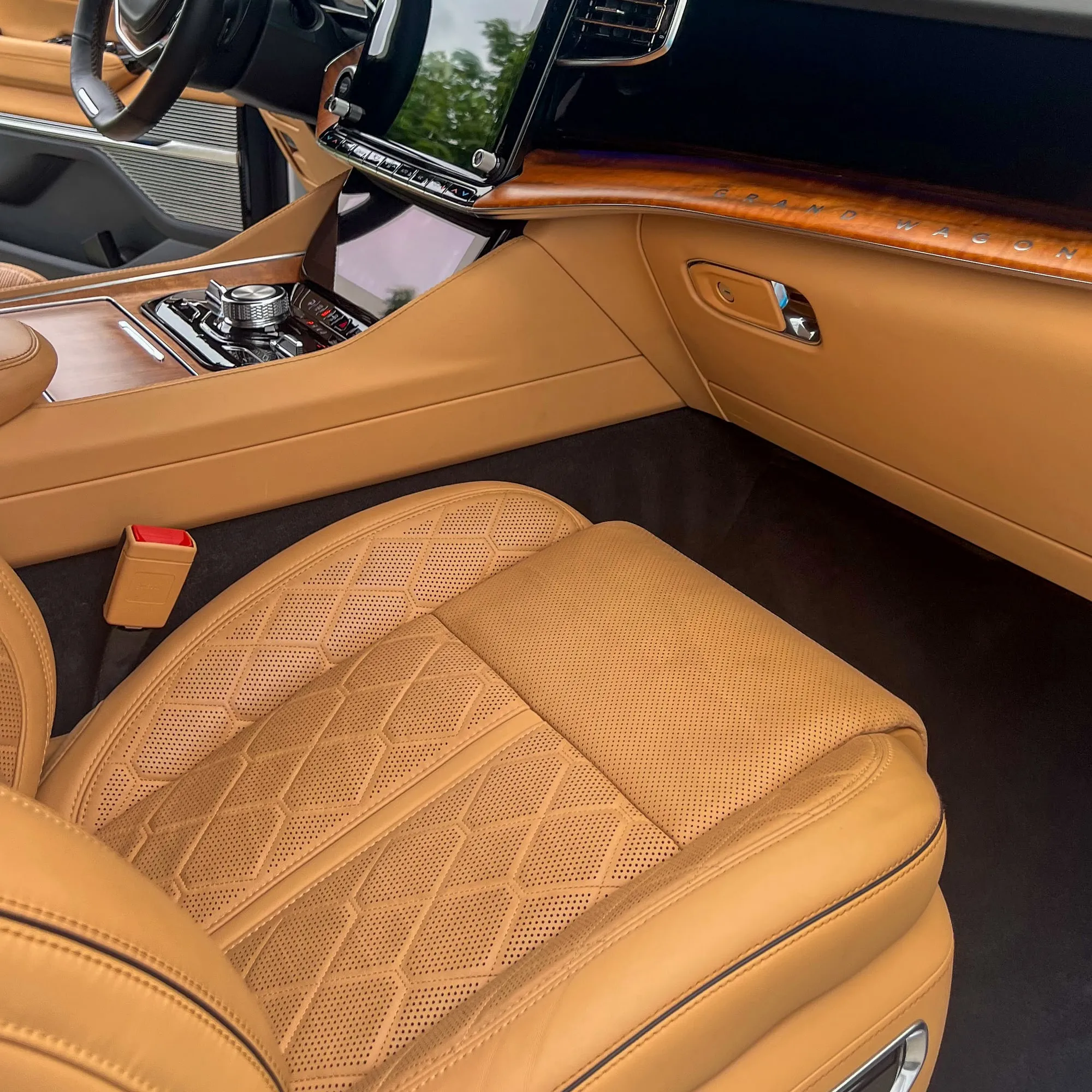 The cleaned interior of a Jeep Grand Wagoneer: quilted tan leather seat, wood trim and center console
