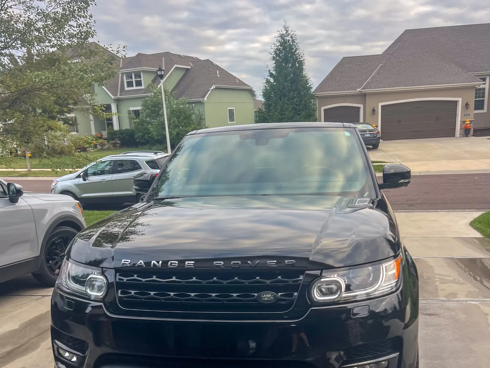 Black Range Rover Sport head-on in a driveway, grille and lower bumper cleaned